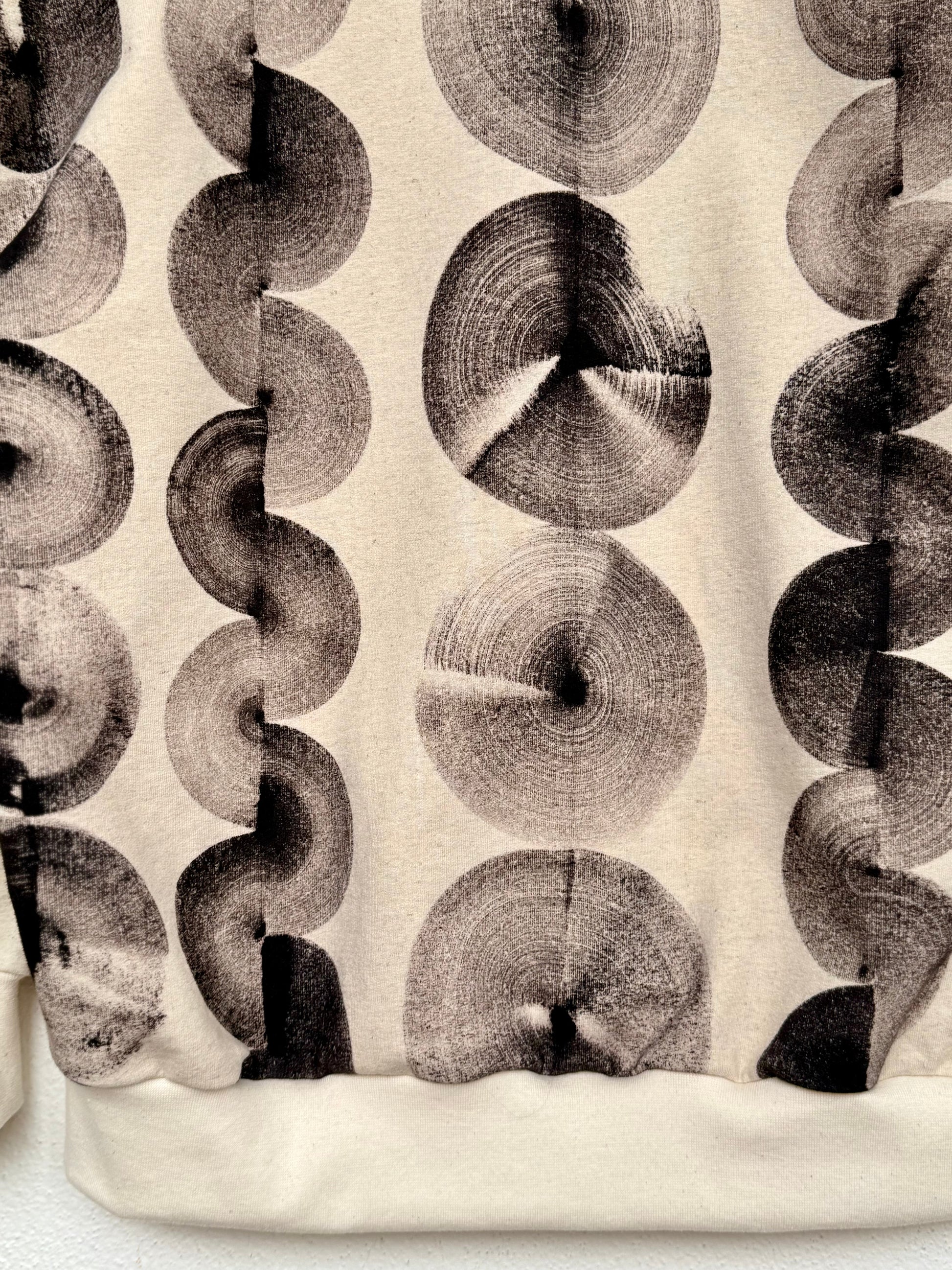 Patterned fabric with circular natural black design on a beige background 