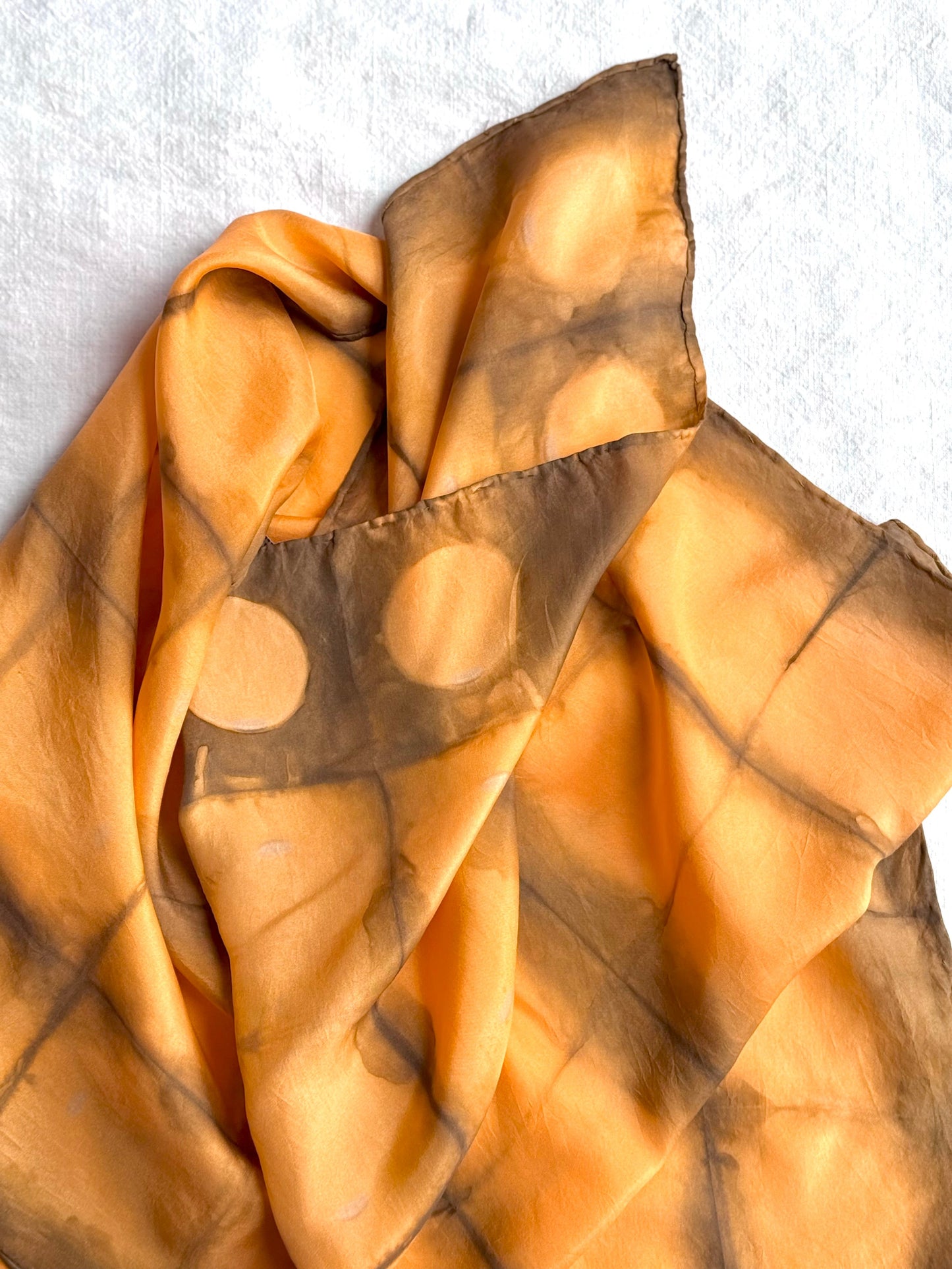 detail od an annatto and sweet chestnut dyed shibori silk scarf