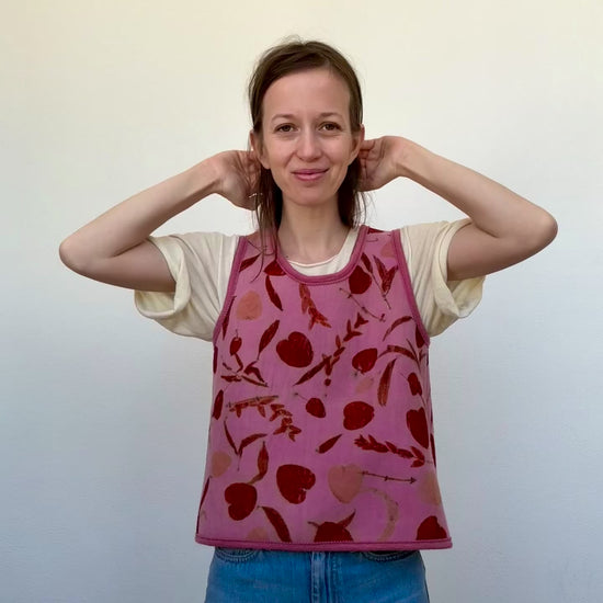 woman wearing a naturally dyed and eco-printed pink and orange colored woolen vest 