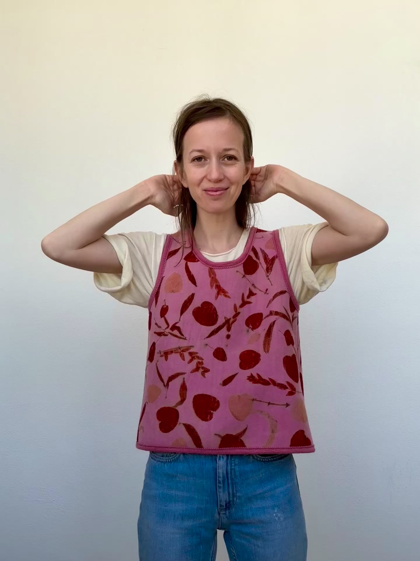 woman wearing a naturally dyed and eco-printed pink and orange colored woolen vest 