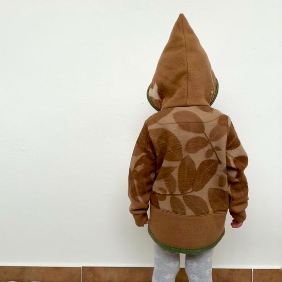 child wearing a merino wool hoodie that was dyed with walnut husks and eco-printed with walnut leaves